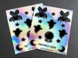 Custom holographic sticker sheets with colorful designs and rainbow shimmer on white surface - Sticker Sheet Printing
