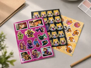 Sticker vinyl sheets stacked with colorful anime illustrations showing vibrant CMYK printing - Sticker Sheet Printing